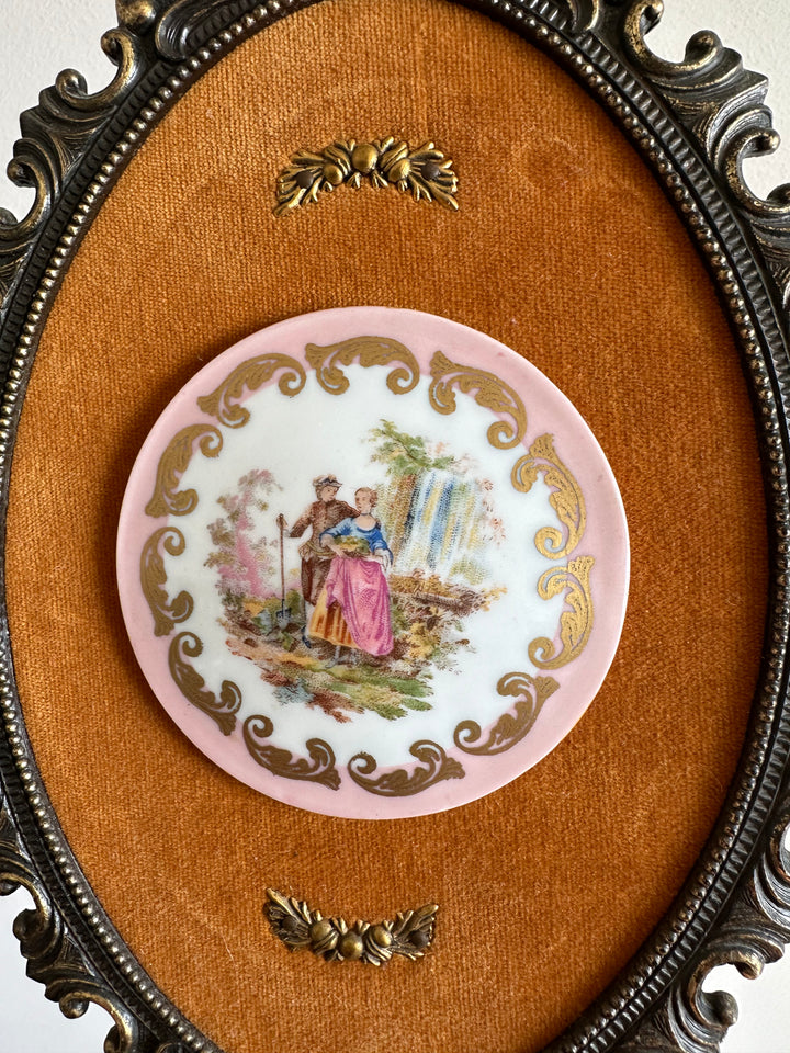 Pastilles en porcelaine sur fond de tissu orange, cerclée de métal doré style rococo