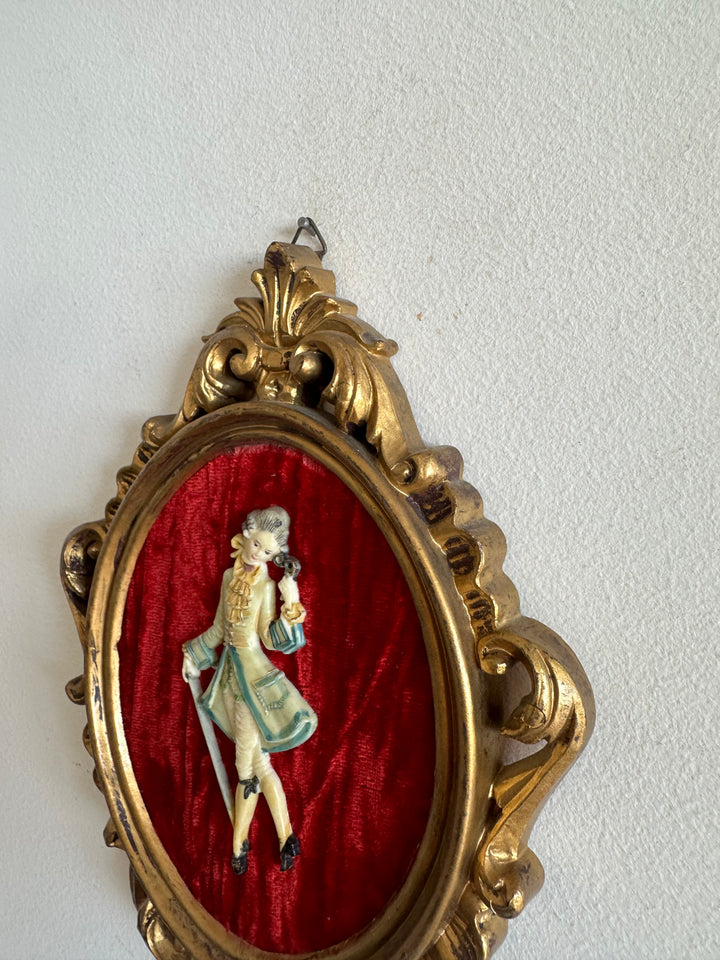 Figurine sur fond de velours rouge encadrement rococo doré