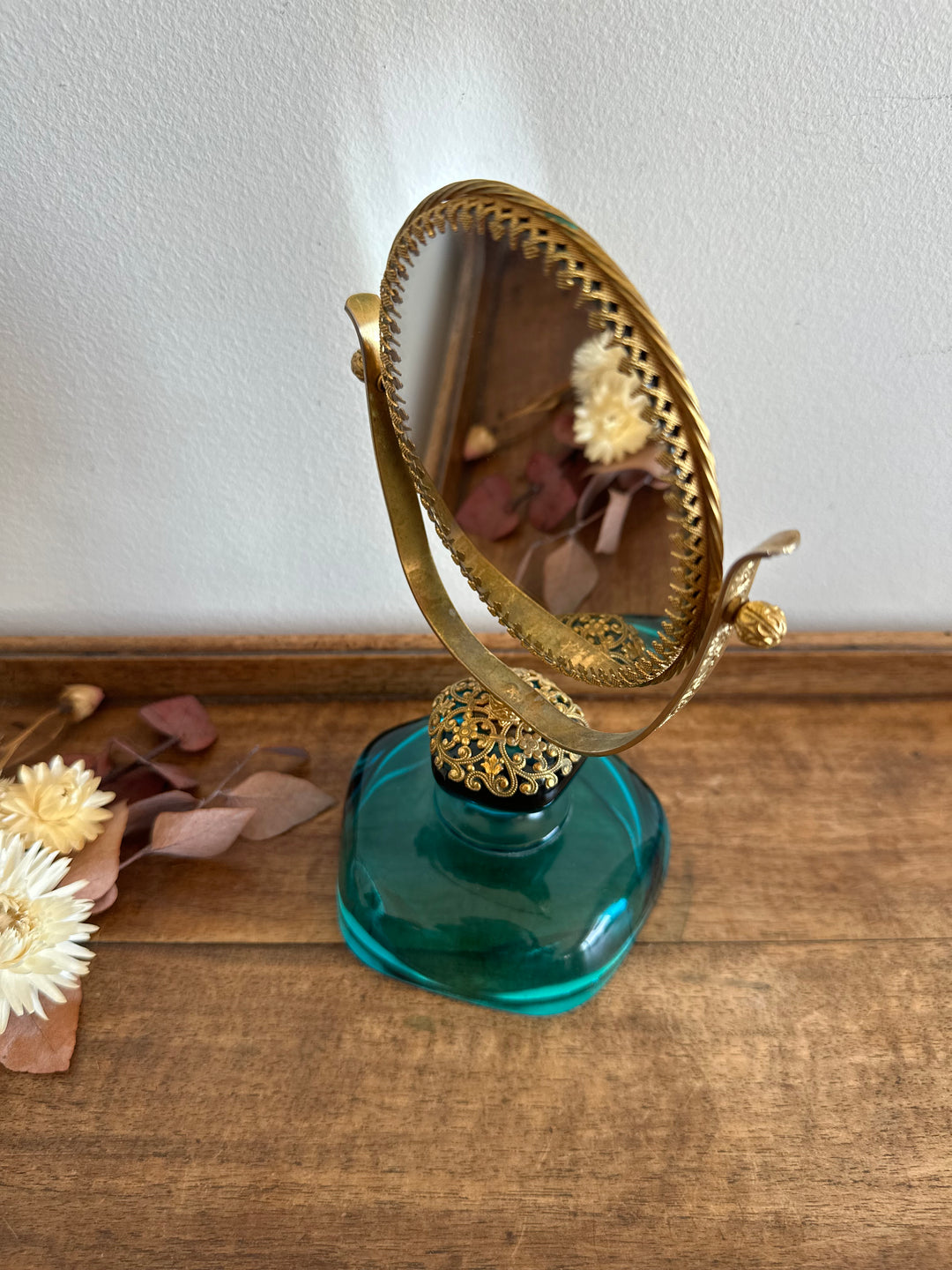 Miroir à poser en laiton dentelé sur socle en verre bleu