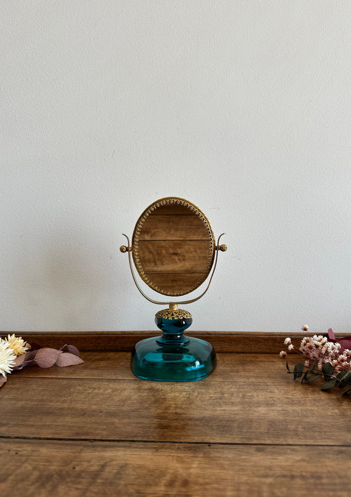 Miroir à poser en laiton dentelé sur socle en verre bleu