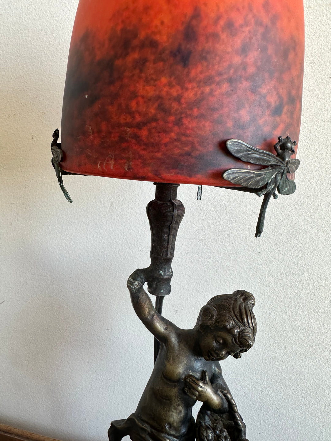 Lampe en bronze fillette au panier globe en verre rouge