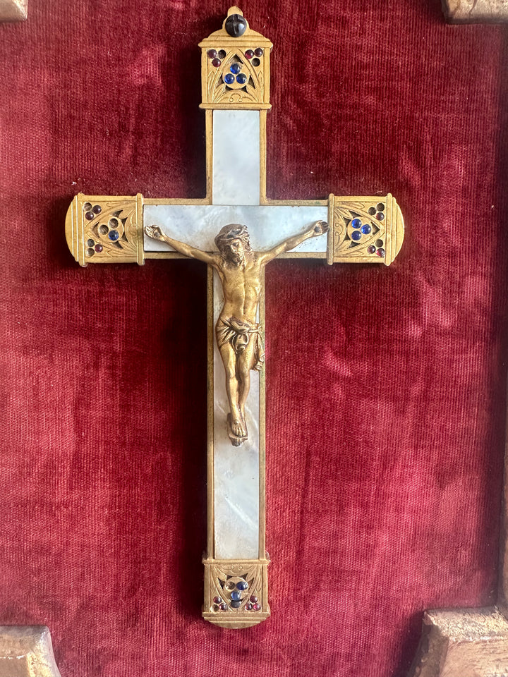 Crucifix en laiton et nacre encadré sur fond de velours rouge grenat