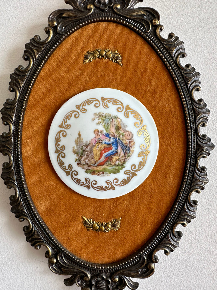 Pastilles en porcelaine sur fond de tissu orange, cerclée de métal doré style rococo