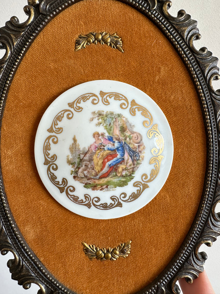 Pastilles en porcelaine sur fond de tissu orange, cerclée de métal doré style rococo