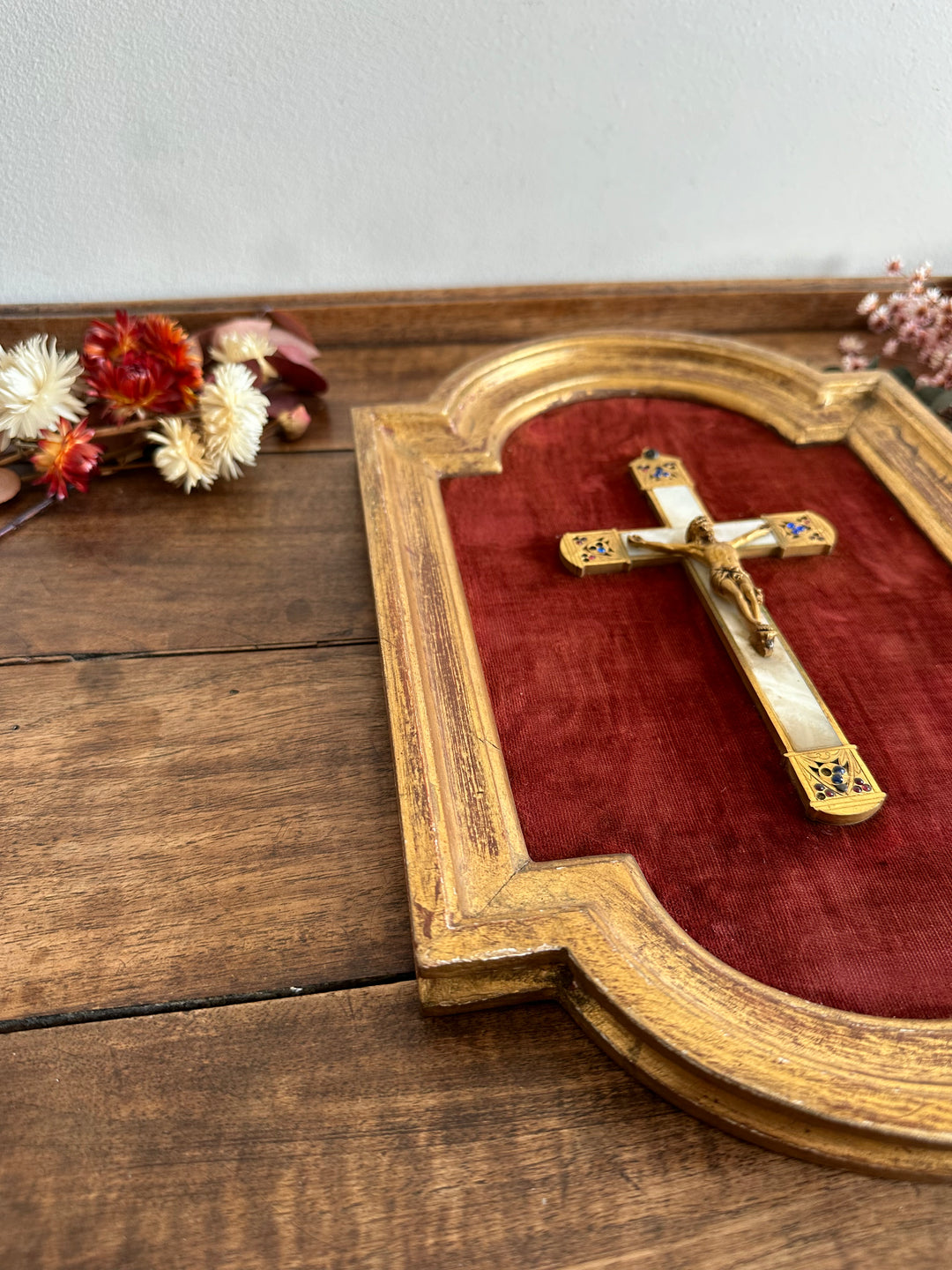 Crucifix en laiton et nacre encadré sur fond de velours rouge grenat