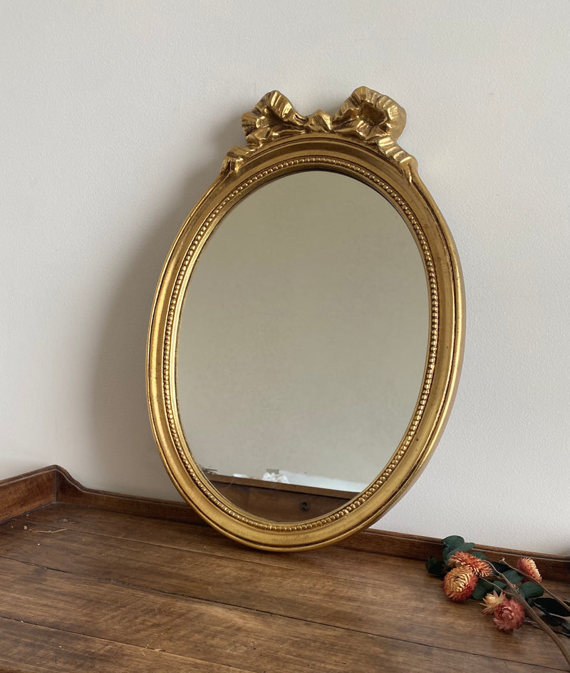 Miroir ovale en bois doré, style baroque avec nœud