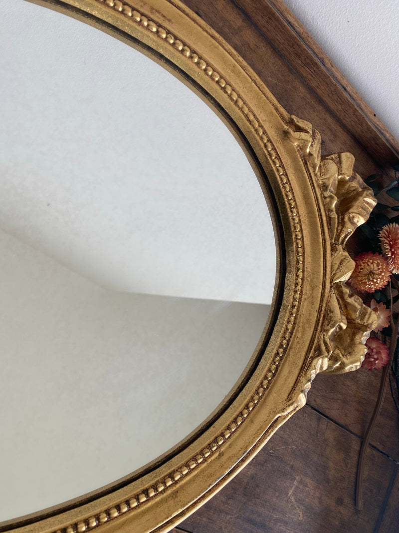 Miroir ovale en bois doré, style baroque avec nœud