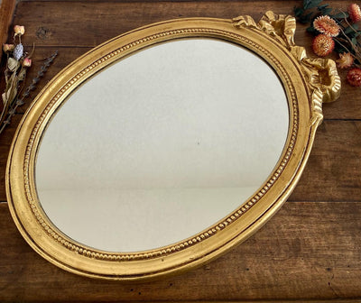 Miroir ovale en bois doré, style baroque avec nœud