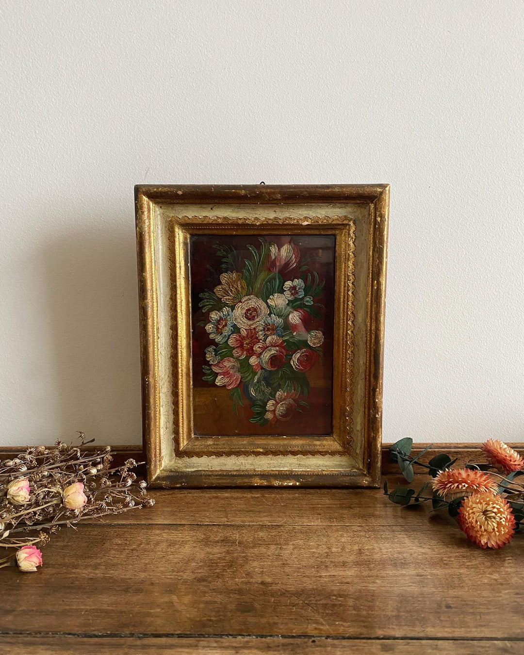 Bouquet de fleurs sur fond marron dans son cadre mordoré en bois