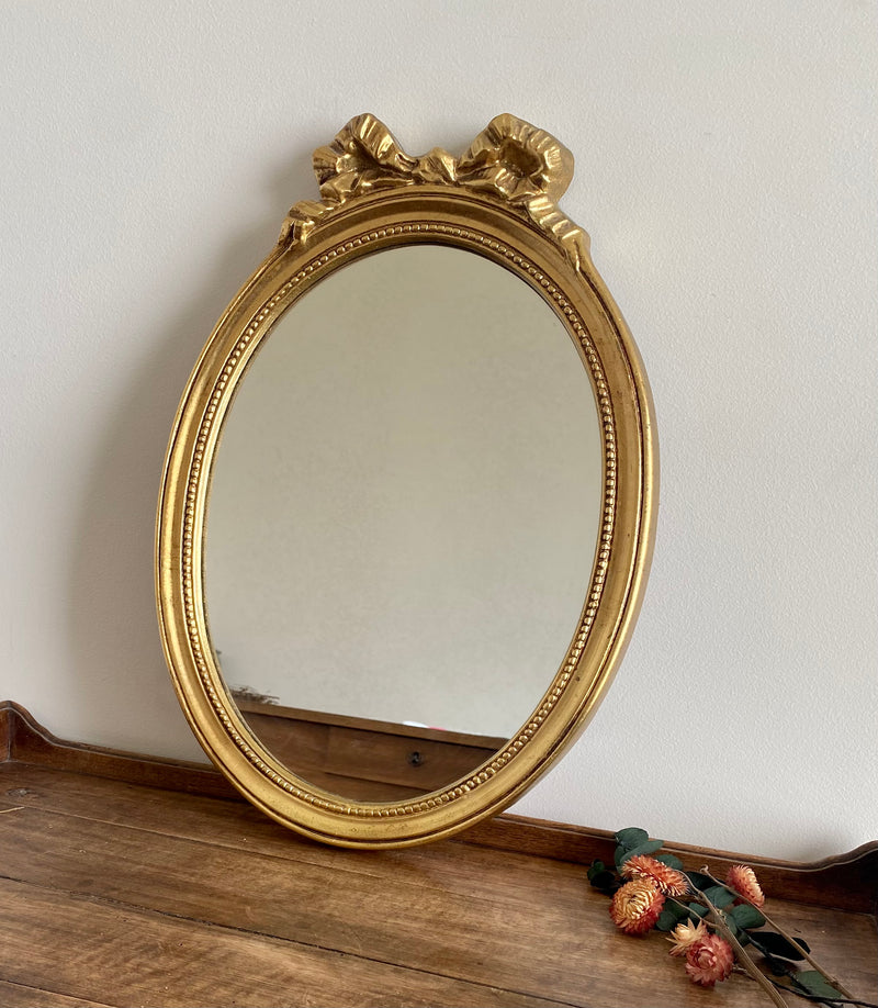 Miroir ovale en bois doré, style baroque avec nœud