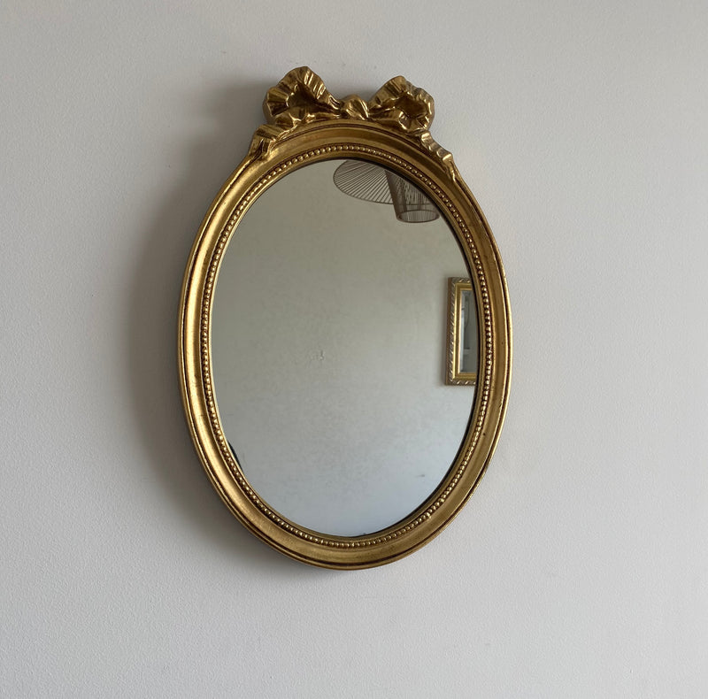 Miroir ovale en bois doré, style baroque avec nœud