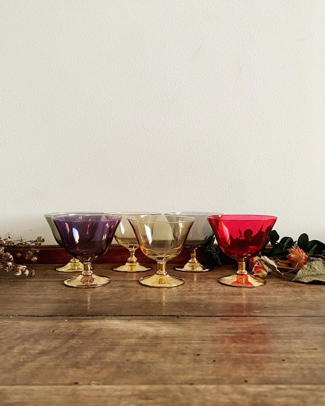 Verres à liqueur colorés sur pieds dorés.